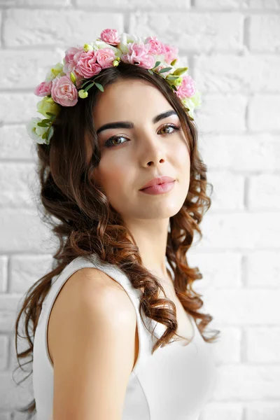 Hermosa joven con flores en la cabeza — Foto de Stock