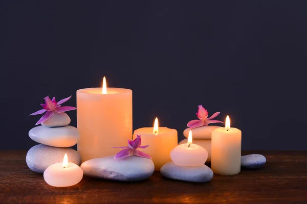 Pedras de spa com velas ardentes e flores — Fotografia de Stock