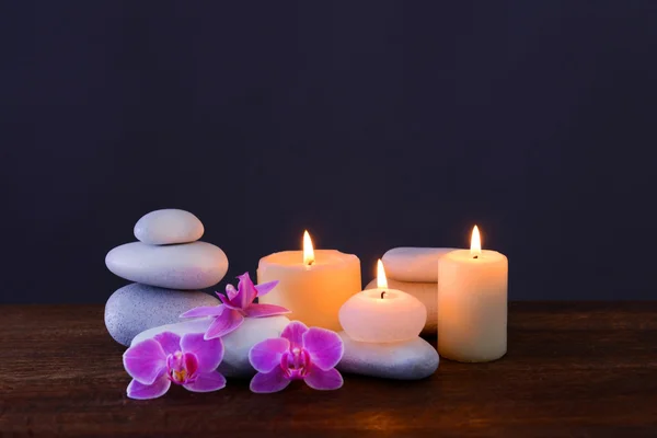 Piedras de spa con velas y flores encendidas — Foto de Stock