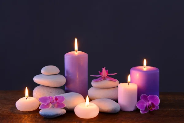 Pedras de spa com velas ardentes e flores — Fotografia de Stock