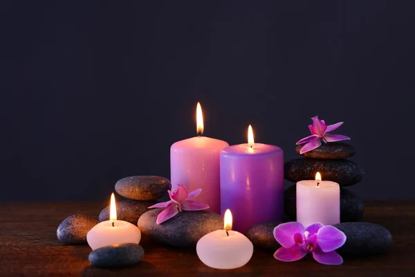 Piedras de spa con velas y flores encendidas — Foto de Stock