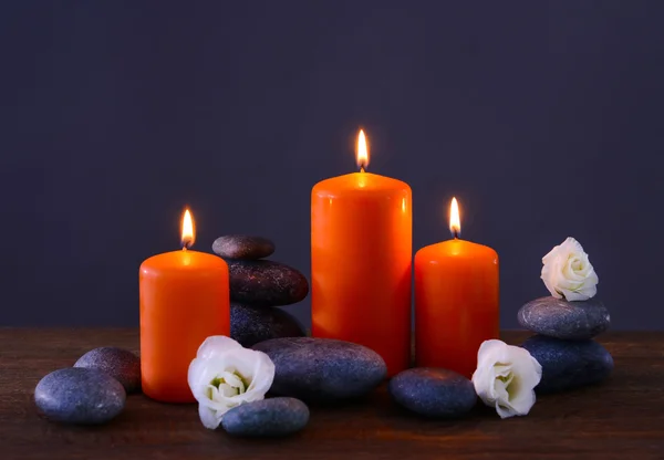 Pedras de spa com velas ardentes e flores — Fotografia de Stock