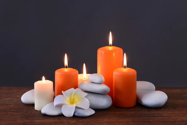 Piedras de spa con velas encendidas y flores —  Fotos de Stock