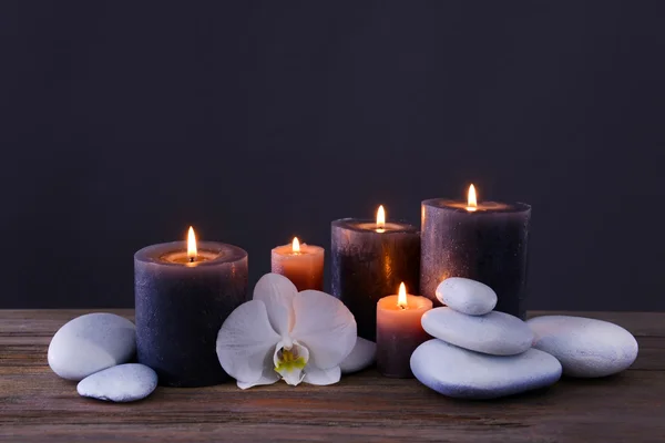 Pedras de spa com velas ardentes e flor — Fotografia de Stock