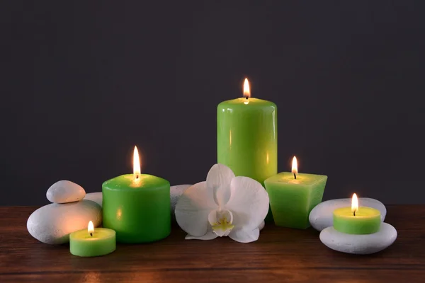 Pedras de spa com velas ardentes e flor — Fotografia de Stock