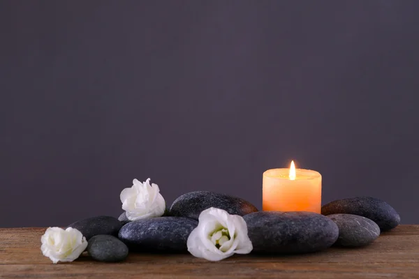 Wellness-Steine mit brennender Kerze und Blumen — Stockfoto