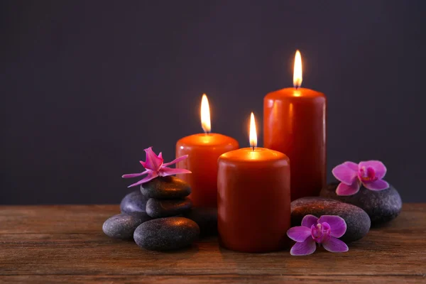 Piedras de spa con velas y flores encendidas —  Fotos de Stock