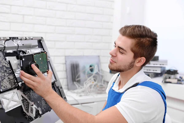 Jovem reparador desmontando um computador peças internas no centro de serviço — Fotografia de Stock