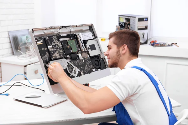 Young repairer working with screwdriver in service center