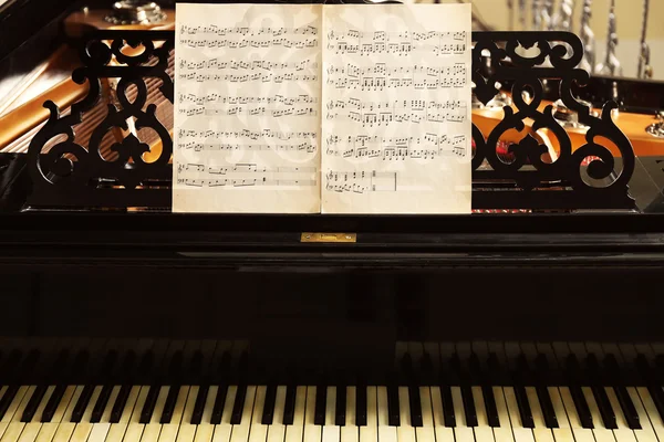 Notas musicales sobre piano negro — Foto de Stock