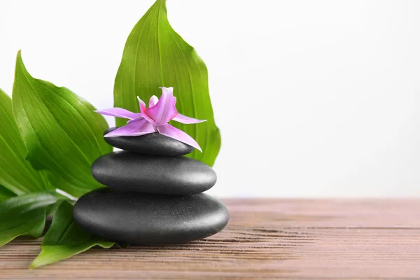 Black spa stones with leaves — Stock Photo, Image