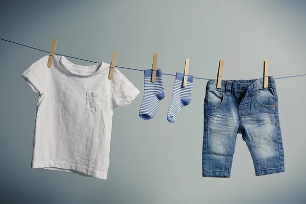 Baby clothes hanging on rope — Stock Photo, Image