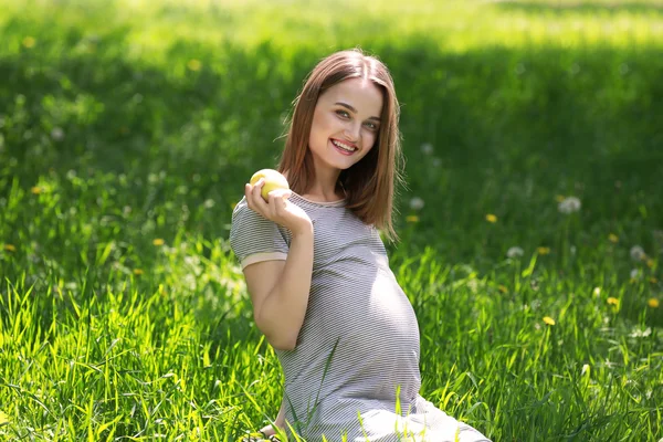 Красивая беременная женщина ест яблоко — стоковое фото