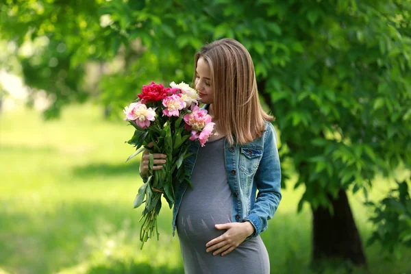 Zwangere vrouw met pioenroos boeket — Stockfoto