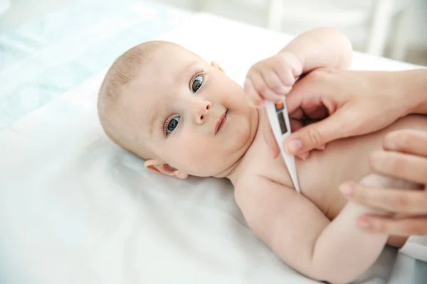 Médecin prenant la température du bébé — Photo