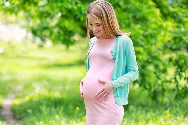Wanita hamil yang cantik di taman — Stok Foto