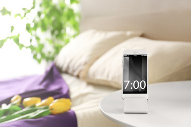 Smart phone with stand on a bedside table in a room clipart