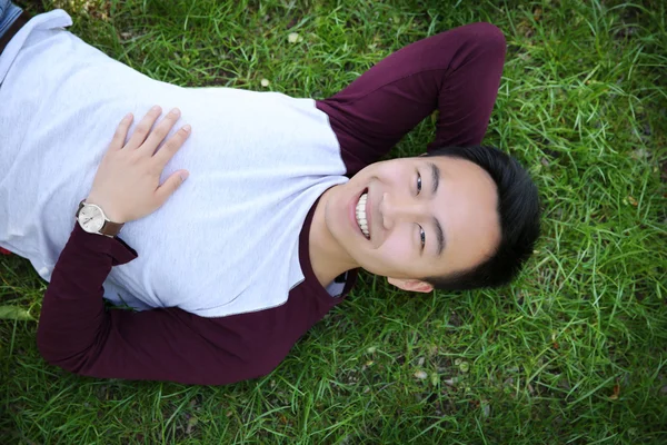 Mann liegt auf grünem Gras — Stockfoto