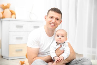 Baba bebeği tutuyor.