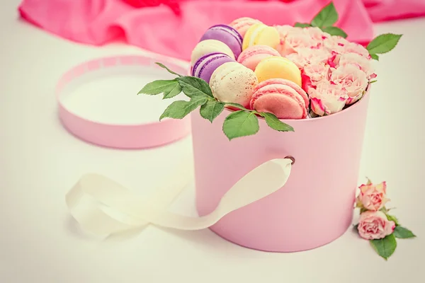 Tasty macaroons and roses in box — Stock Photo, Image