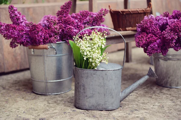 Purple lilac and may-lilies in metal bucket — Stock Photo, Image