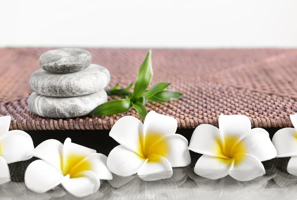 Pedras de spa cinza com flores de plumeria — Fotografia de Stock