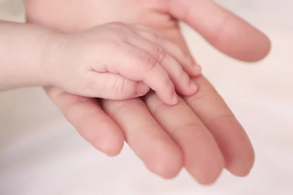 Barnets hand hålla överordnade hand — Stockfoto