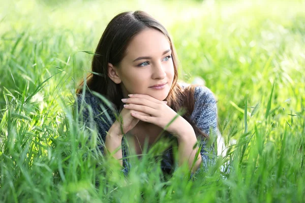 Meisje opleggen van groen gras — Stockfoto