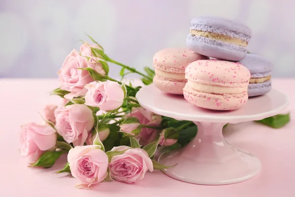 Sabrosos macarrones con hermosas rosas —  Fotos de Stock