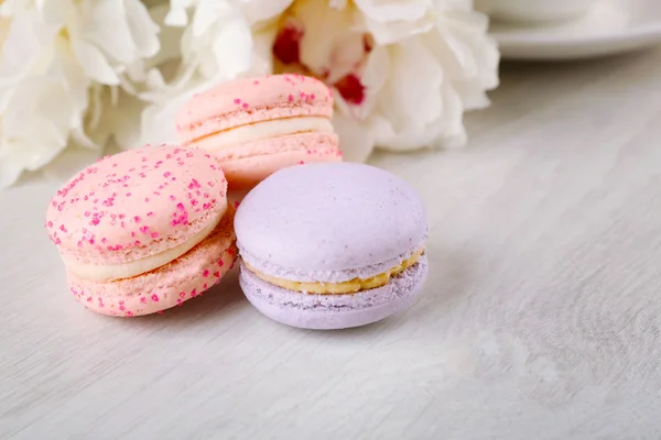 Tasty macaroons with beautiful peonies — Stock Photo, Image