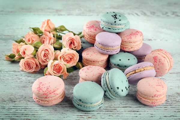 Tasty macaroons with beautiful roses — Stock Photo, Image