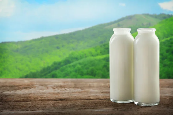 Lahví mléka na stole — Stock fotografie