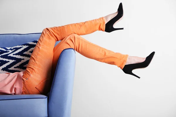 Woman legs on sofa with stylish shoes — Stock Photo, Image