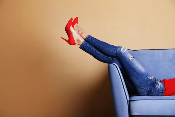 Kobieta nogi na kanapie z stylowe buty — Zdjęcie stockowe