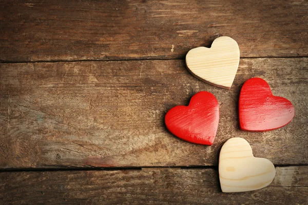 Corazones de madera sobre fondo de madera — Foto de Stock