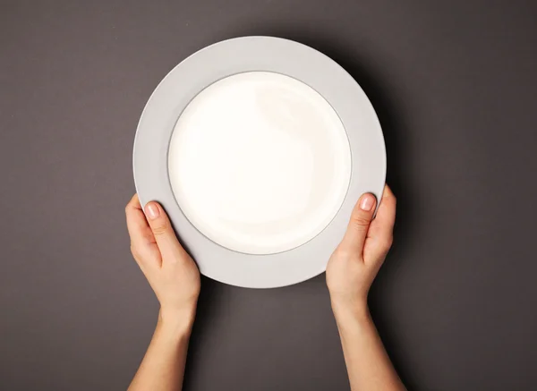 Ženské ruce a prázdný talíř — Stock fotografie