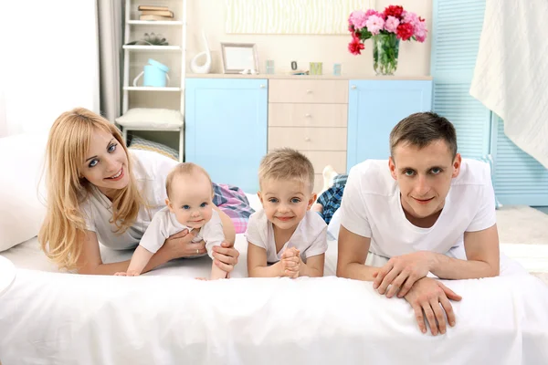 Happy family on white bed — Stock Photo, Image