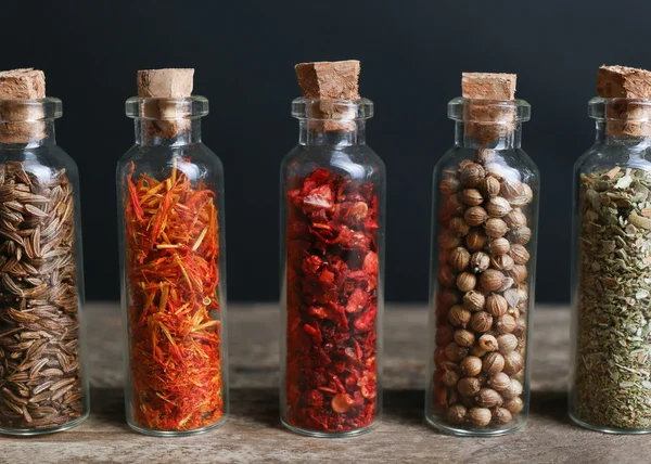 Différentes épices dans de petites bouteilles en verre — Photo