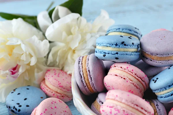 Bowl with macaroons and peonies — Stock Photo, Image