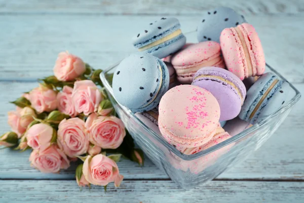 Sabrosos macarrones con hermosas rosas — Foto de Stock