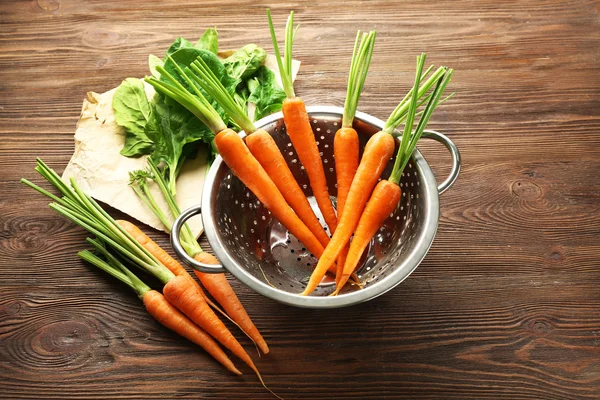 Морковь в дуршлаге на столе — стоковое фото
