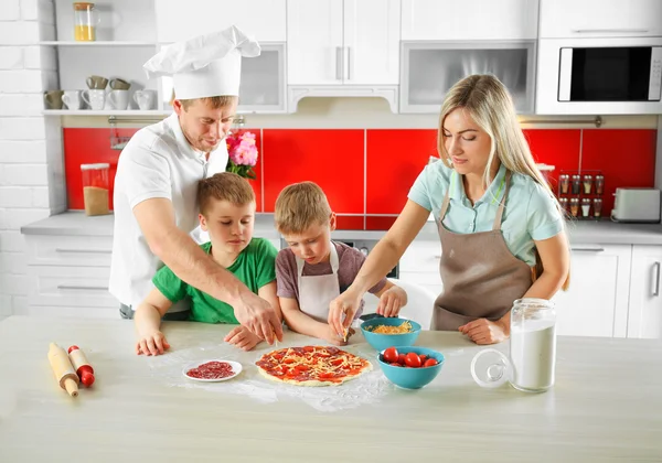 Счастливая семья делает пиццу — стоковое фото