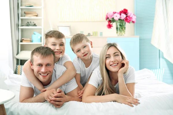 Mooie en gelukkige familie op bed — Stockfoto