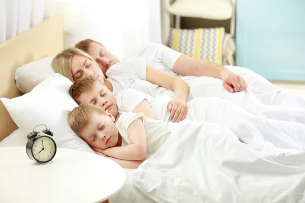 Спящая семья в постели — стоковое фото