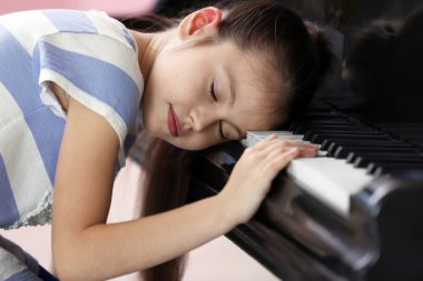 Piyano tuşlarında uyuyan kız