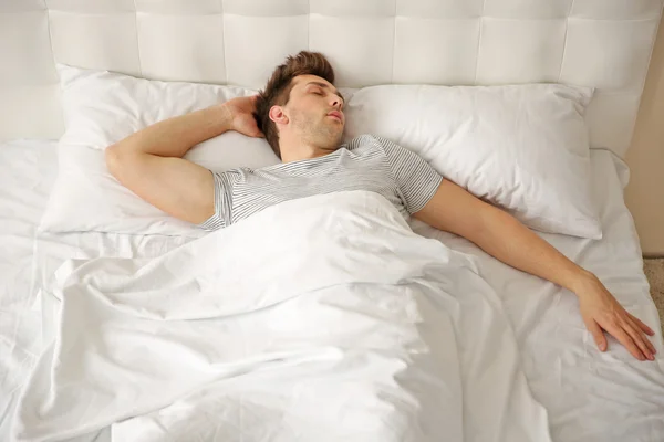Молодой человек, спящий в постели — стоковое фото
