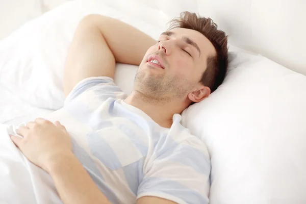 Молодий чоловік спить на ліжку — стокове фото