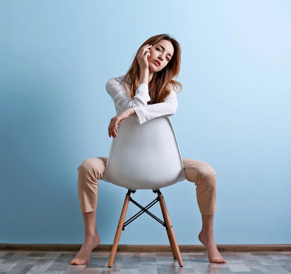 Mooie jonge vrouw zitten in de stoel — Stockfoto