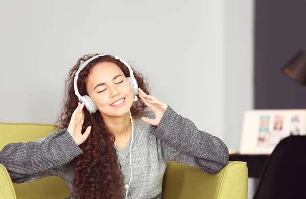 Vrouw luisterend naar muziek in hoofdtelefoon — Stockfoto