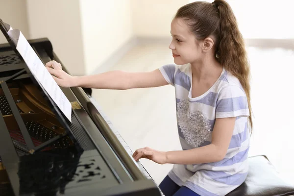 Маленькая девочка играет на пианино — стоковое фото